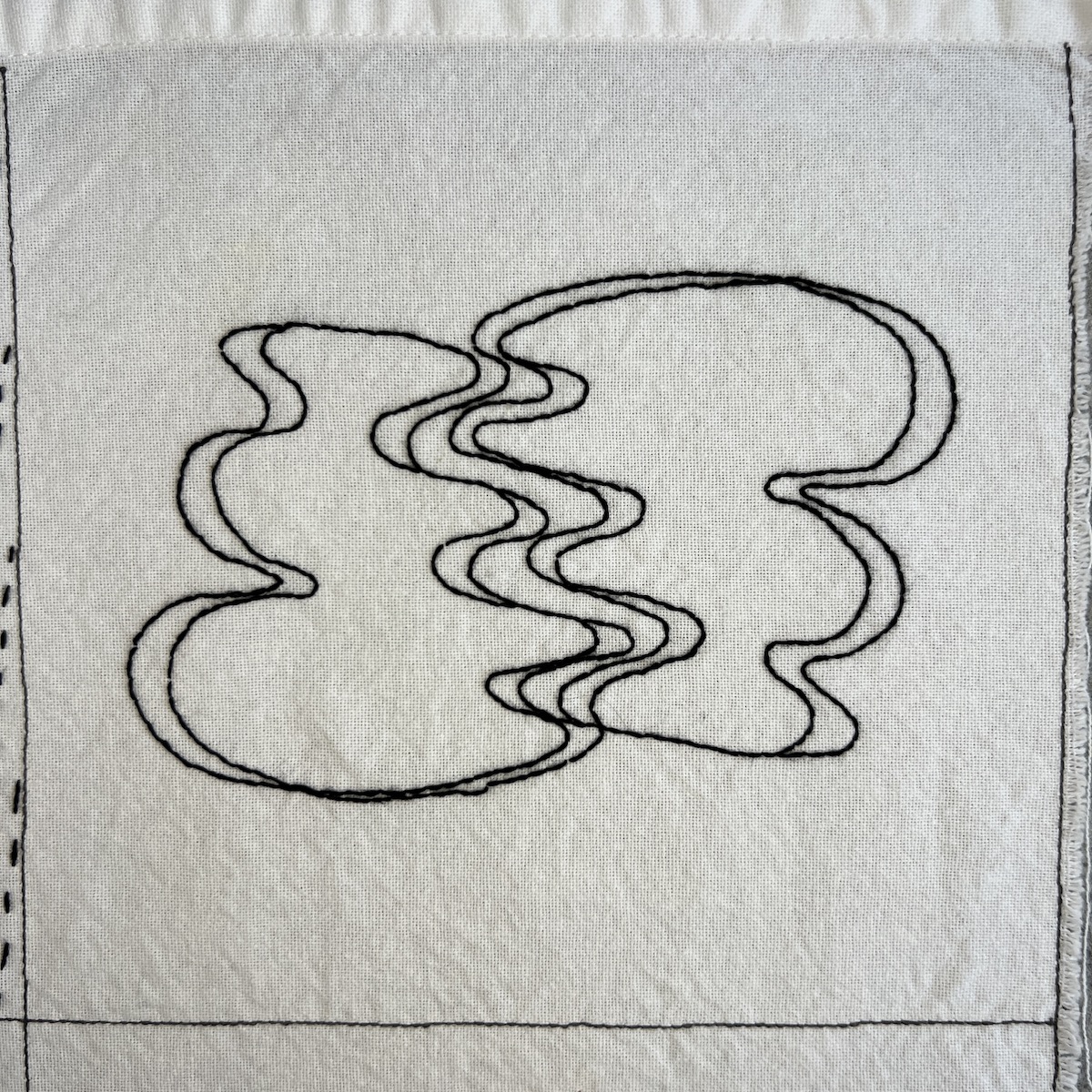 Overhead photo of white fabric 8”x8” square. A wobbly rounded shape that overlap a few times is embroidered in black thread.