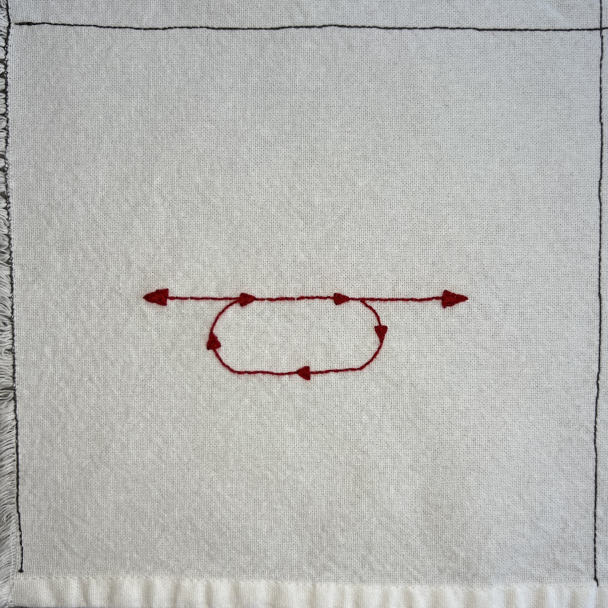 Overhead photo of white fabric 8”x8” square, with red embroidered lines in the center in the shape of an oval with a horizontal line above it, with arrows at each end of the line. Arrows show directionality in the oval, going in a clockwise loop