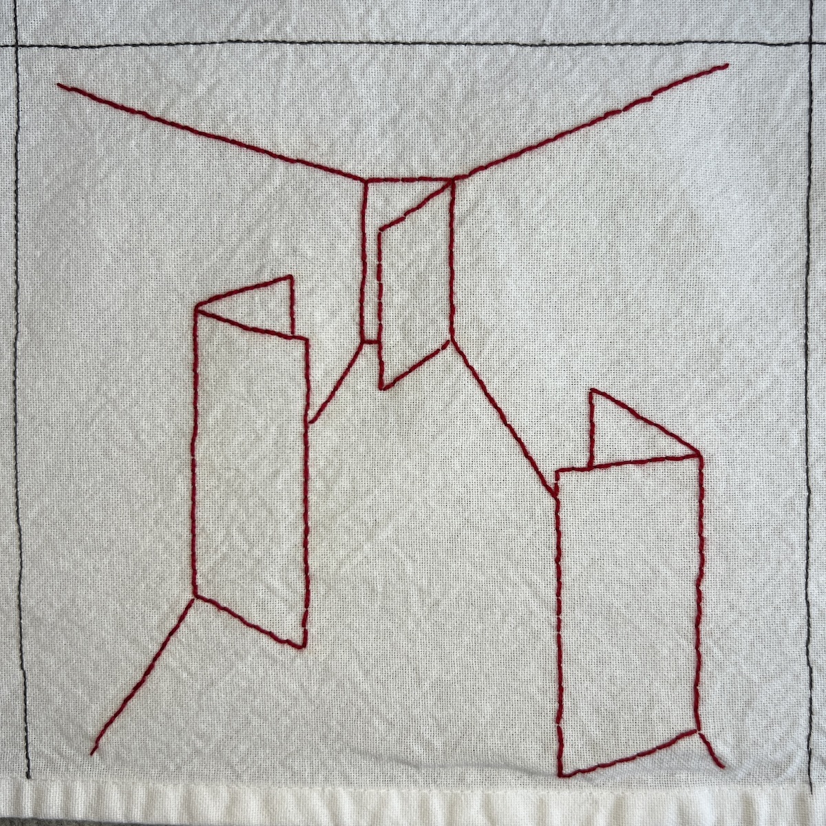 Overhead photo of white fabric 8”x8” square. Red thread makes stitched lines to create the perspective of looking down a hallway. There’s a door that’s ajar at the very end of the hallway. Two other doors are ajar along the hallway, one on the left and one on the right.