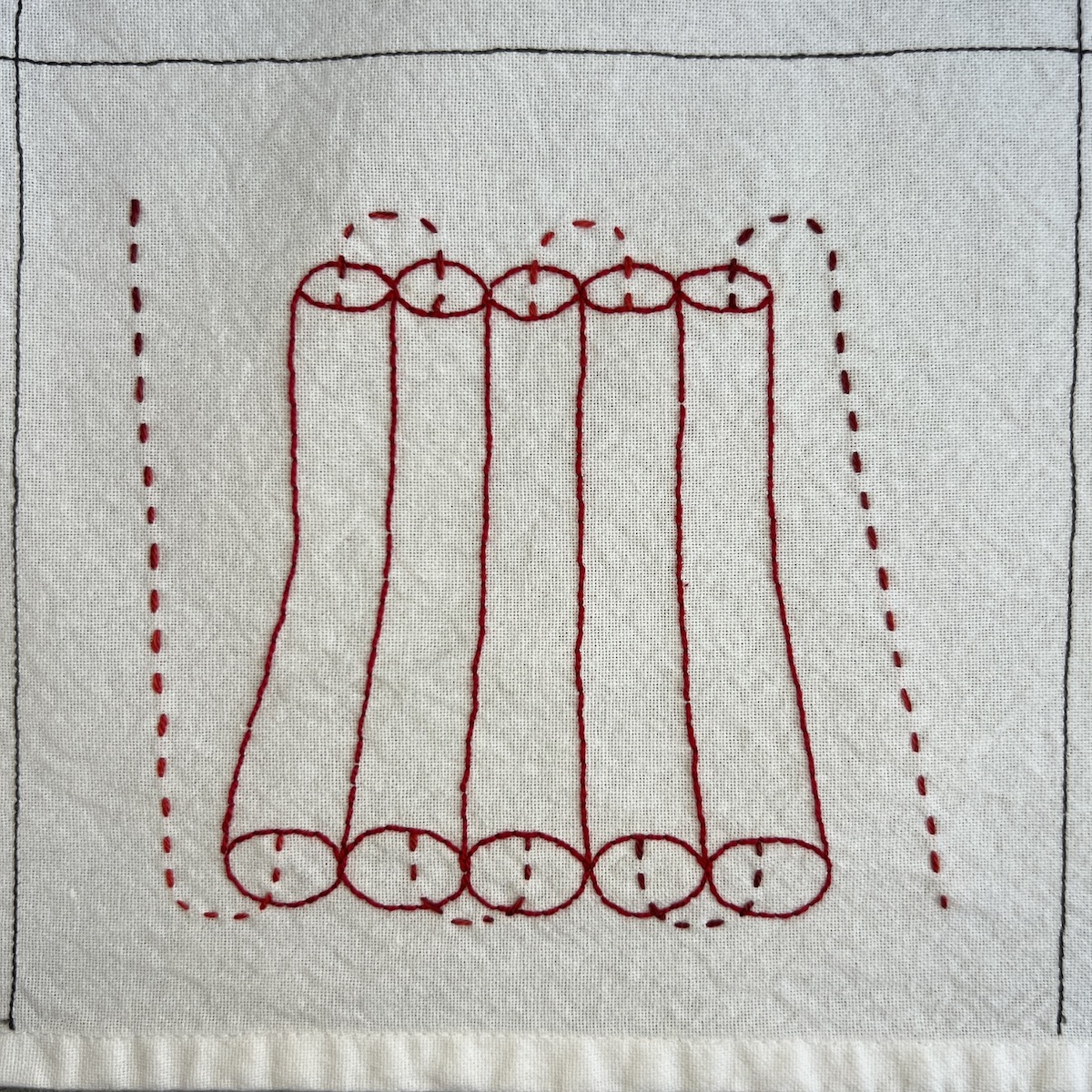 Overhead photo of white fabric 8”x8” square, with a series of 5 bent pipes next to each other and a dashed line weaving in and out of each pipe.