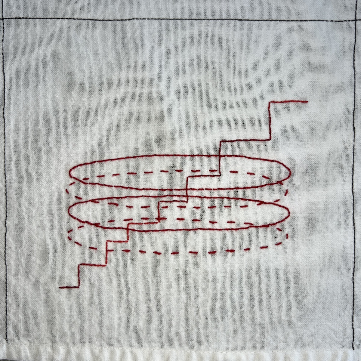 Overhead photo of white fabric 8”x8” square, with red embroidered lines. There’s a stepped line going diagonally from the bottom left to top right corner, with 4 overlapping oval lines embroidered on top of that.